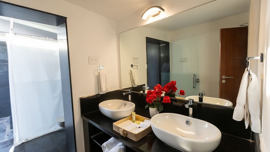 an image of a well appointed bathroom with a huge mirror featuring two wash basins
