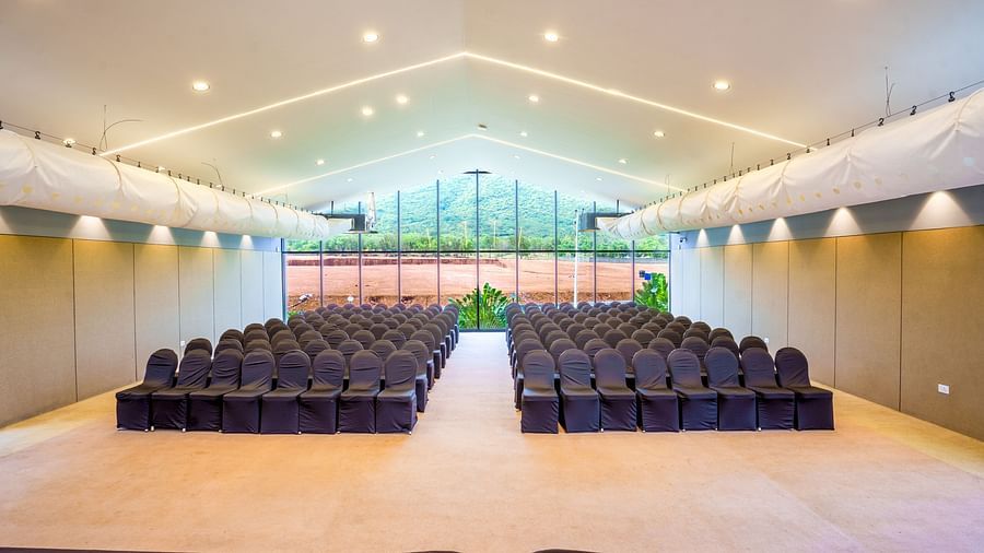 Brightly lit Love Letter at Darza Resort arranged with rows of dark chairs facing a stage area