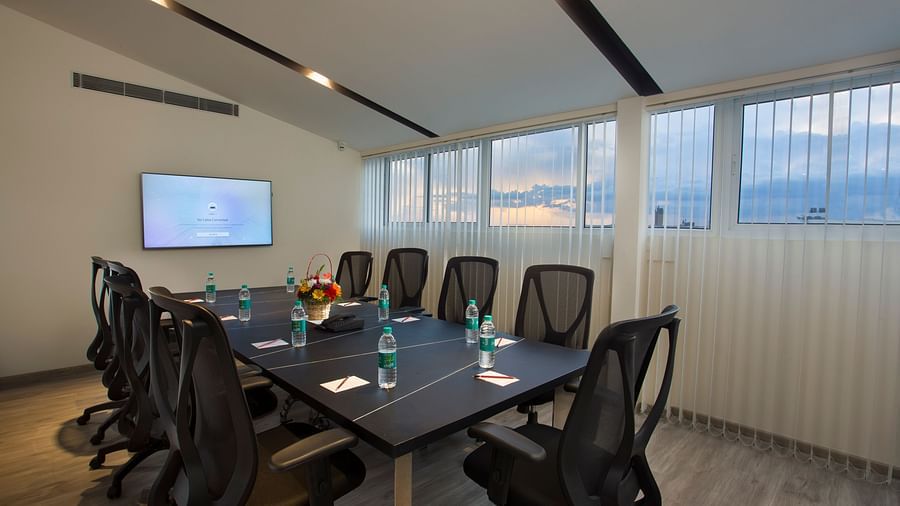 A well-lit conference room with a long table, chairs and a large screen for presentations - De Venetian by TGI, Brookefield