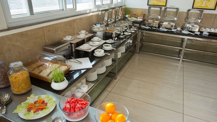 A hotel breakfast buffet with a variety of food items on display near a window with a city view - De Venetian by TGI, Brookefield