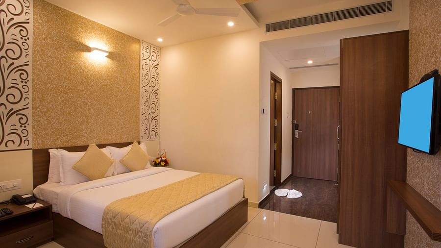Another view of a hotel bedroom with a plush bed, decorative wallpaper and a view into the hallway - De Venetian by TGI, Brookefield