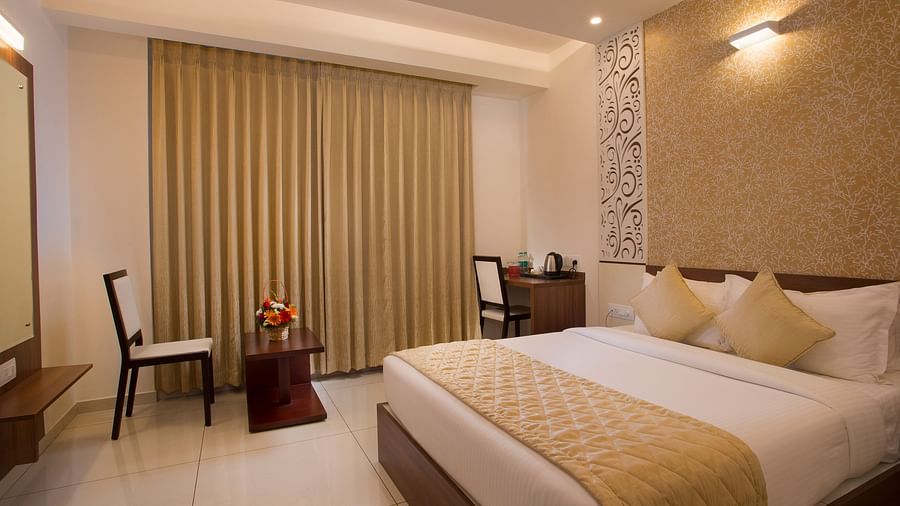 A neatly arranged hotel room with a large window, a plush bed and a patterned accent wall - De Venetian by TGI, Brookefield