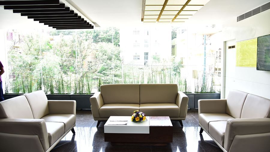 A bright and airy hotel lobby with modern furniture and a view of greenery through floor-to-ceiling windows - De Venetian by TGI, Brookefield