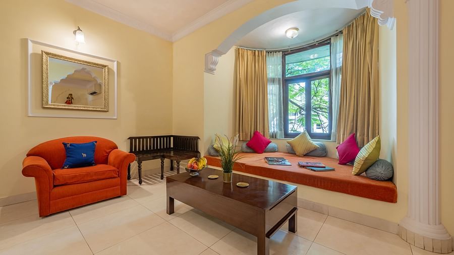 Cosy living room with a bay window, bright cushions, and warm lighting at Dera Rawatsar, Jaipur