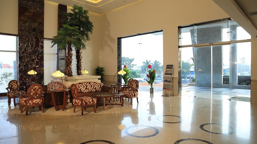 A spacious and elegant hotel lobby with natural lighting, cosy seating, and a welcoming reception area.- Dhanalakshmi Srinivasan Hotels, Perambalur