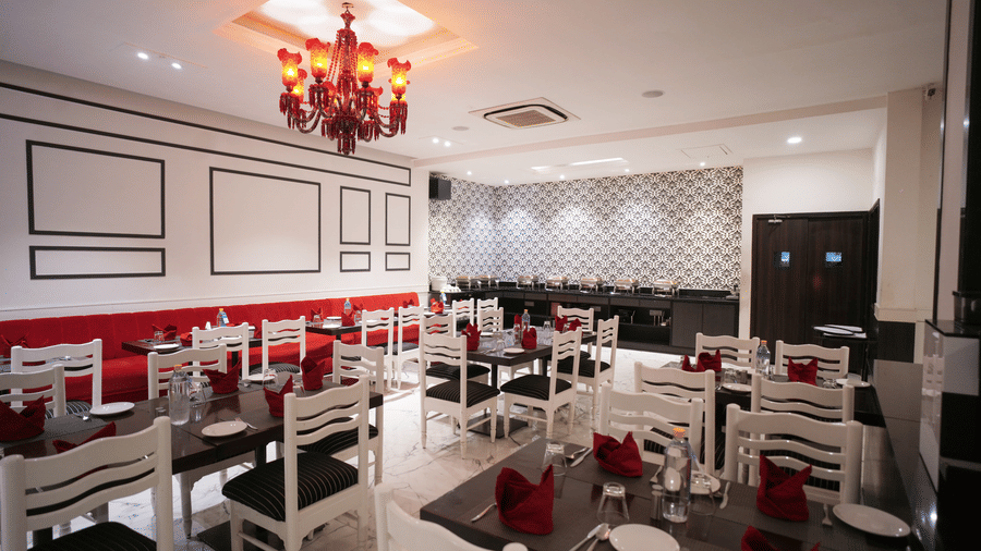 Diamond Hotel Varanasi's dining room offers a modern setting with tiled floors and neatly laid tables.