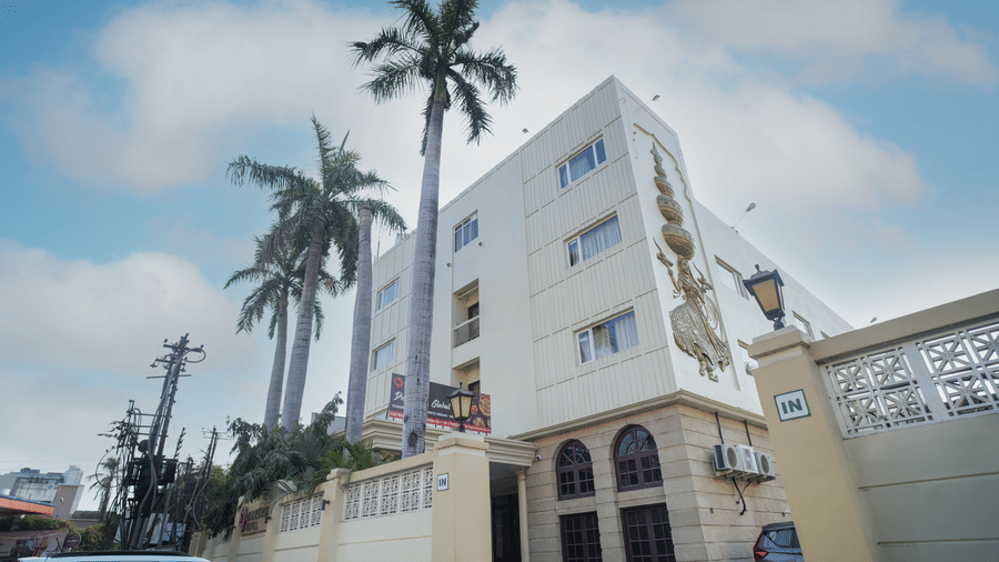 A wide view shows the exterior of Diamond Hotel Varanasi with its distinct architecture and surrounding greenery.
