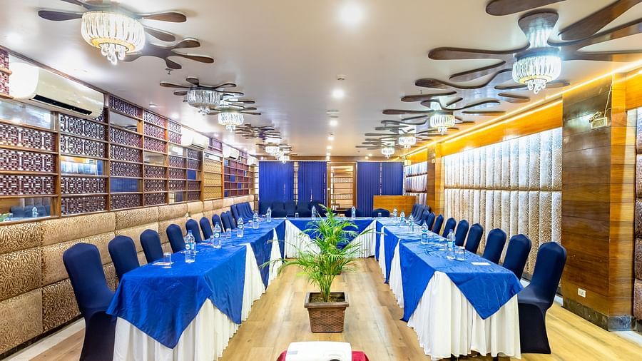 Meeting room at Diamond Palace Lords Plaza Nepalgunj with a U-shaped table facing a screen and decorated walls.