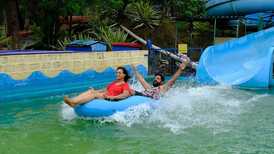couple having fun on a water slide in a rubber raft at an adventure water park | Diamond Parks, Pune 