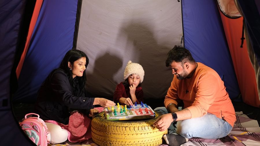 Family playing board games inside a tent at night | Diamond Parks, Pune - Trekking in Pune