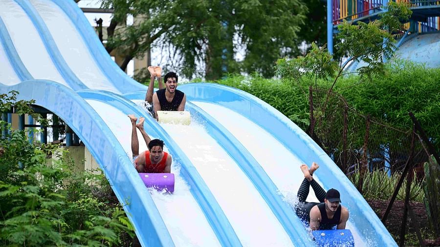 people sliding down a multi-lane water slide at an amusement park | Diamond Parks, Pune 