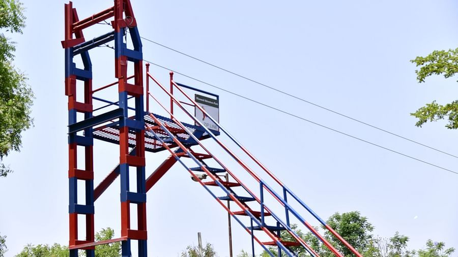 Tall, red and blue steel climbing structure in an outdoor park with clear blue skies | Diamond Parks, Pune