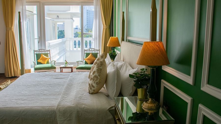 A room at Dileep Kothi, Jaipur with a double bed, side tables and a large window
