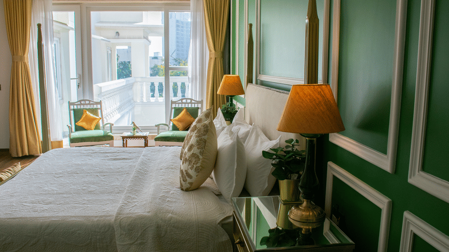 A room at Dileep Kothi, Jaipur, with a double bed, side tables and a large window.