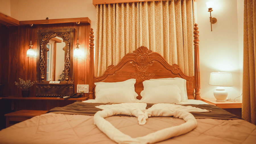 Front view of a Cottage's bedroom featuring a plush king size bed with towel decorations over the bed | Dip Holidays