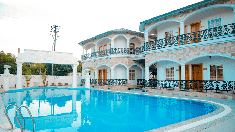 Facade of Dip Holidays featuring a vast swimming pool right in front of the boutique buildings.
