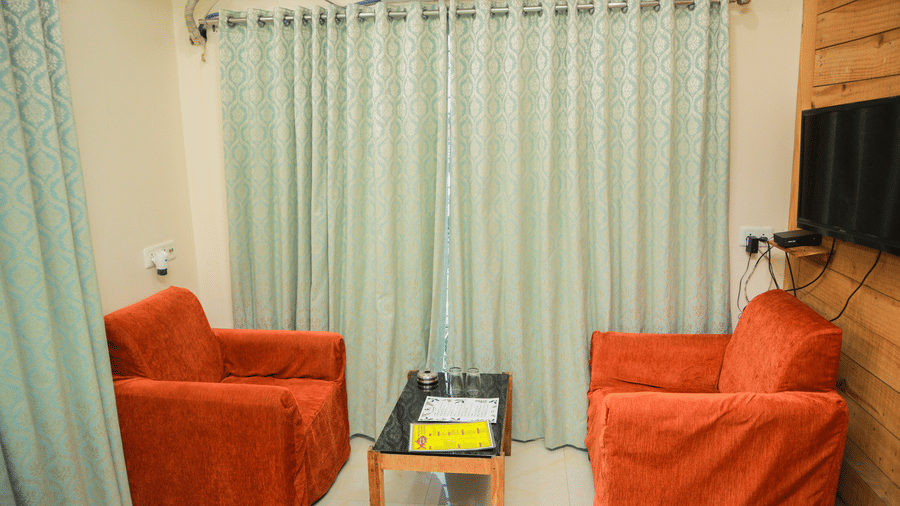 A common seating area with cushioned chairs with a centre table in the middle in a Standard Room at Dip Holidays.