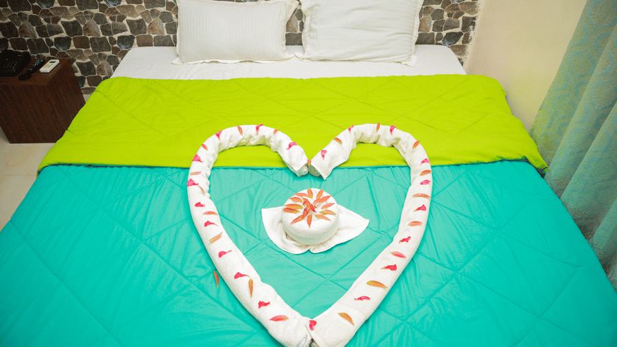 front view of a king size bed with two pillows at the far end of the bed 