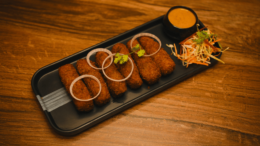 image of indian fritters topped with onion rings served with a dip along with some salad on the side - Dip Holidays, Birbhum