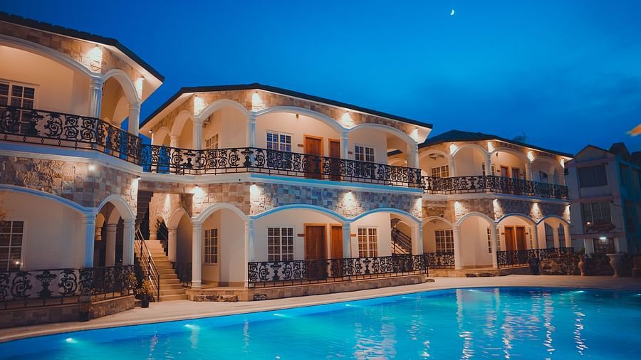 facade image of our hotel in birbhum in the late evening with a beautiful view of the swimming pool in the foreground
