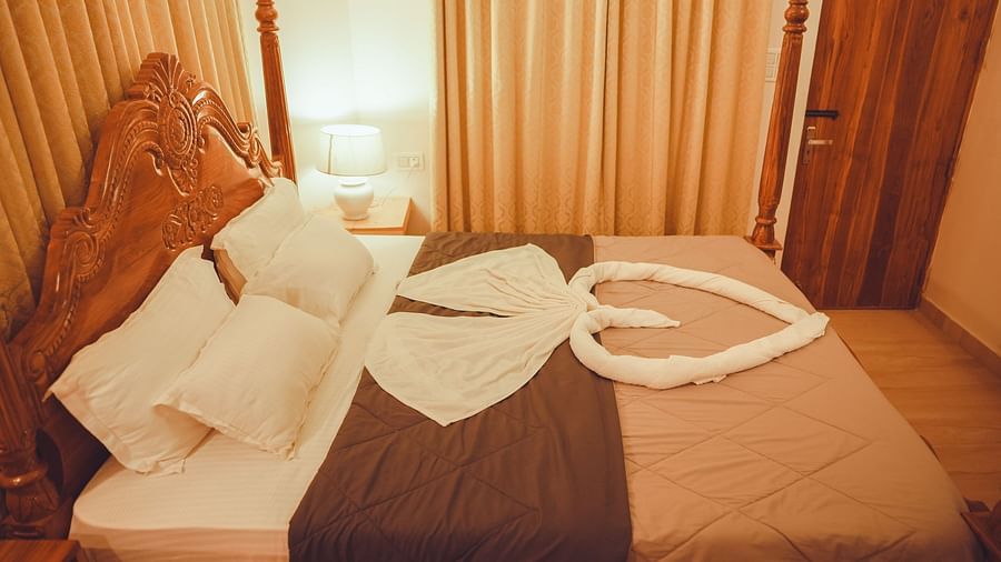 side view image of the king size bed taken from a higher angle featuring a heart shaped towel art on the bed