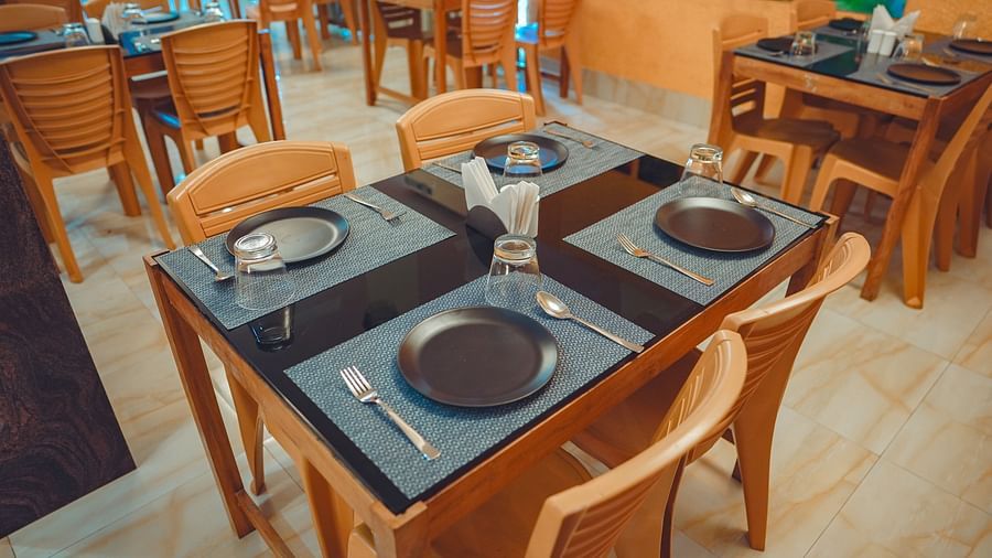 image of a four seater dining area with plates and cutlery well placed on the dining table - Dip Holidays, Birbhum