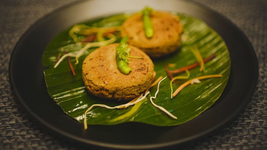 image of a two cutlets placed over a banana leaf topped with green chillies - Dip Holidays, Birbhum