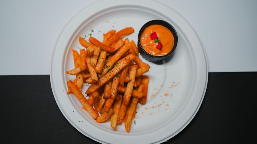 Crispy golden fries served with a spicy dipping sauce, elegantly plated  at D Café, Dip Holidays.