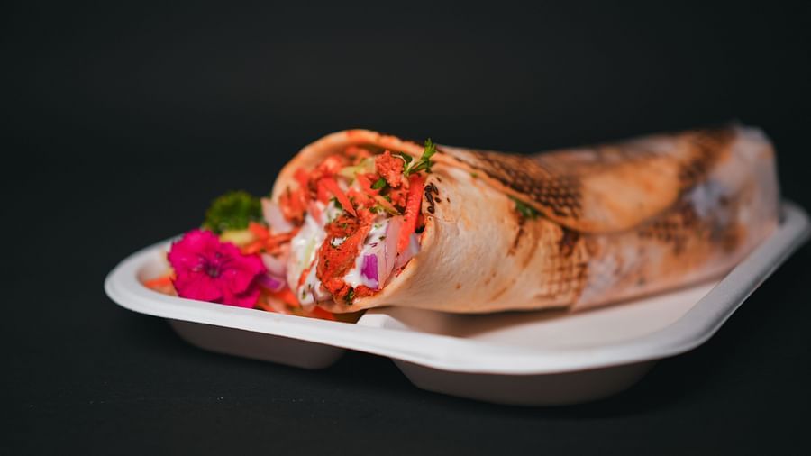 Freshly prepared shawarma wrap served on a tray at D Café in Dip Holidays, filled with vibrant vegetables and garnished for a flavourful presentation.