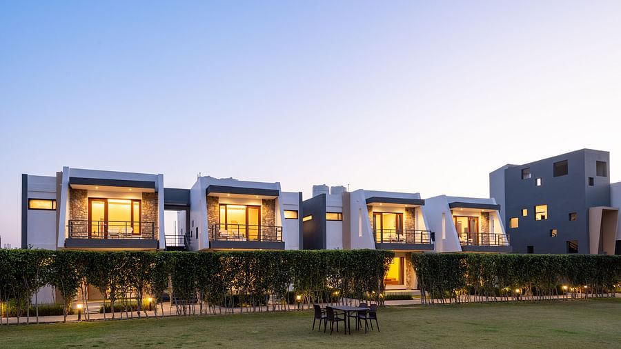 Facade view of DLS Forest Vines Resort, illuminated by warm lights from the windows and doors.