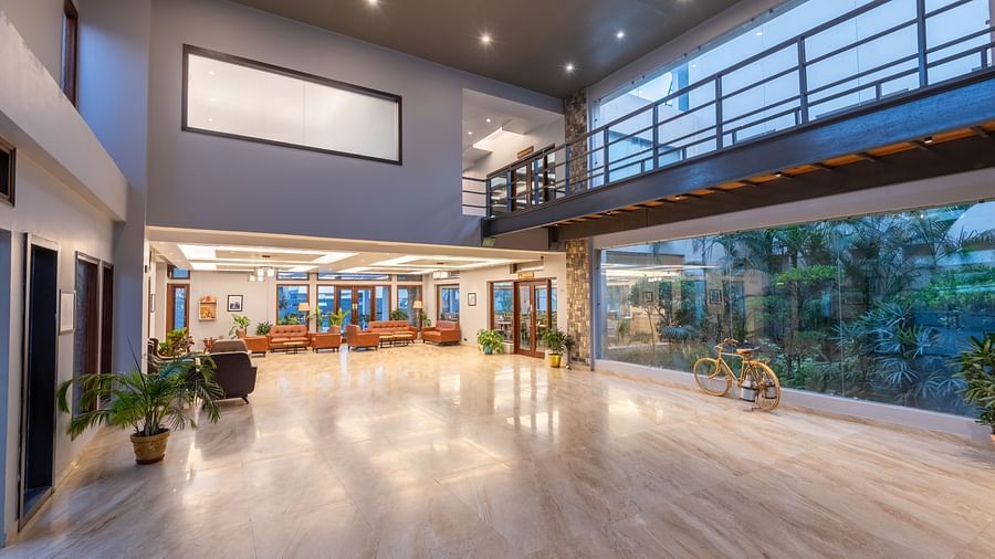 Reception area at DLS Forest Vines Resort viewed from the far end, with bright lighting and cushioned sofas.