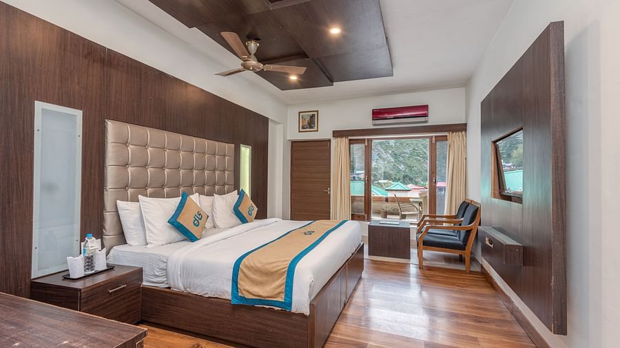 Overview of Premium Room at DLS Spring Valley Resort Dharamshala featuring a king size bed, chair and a balcony