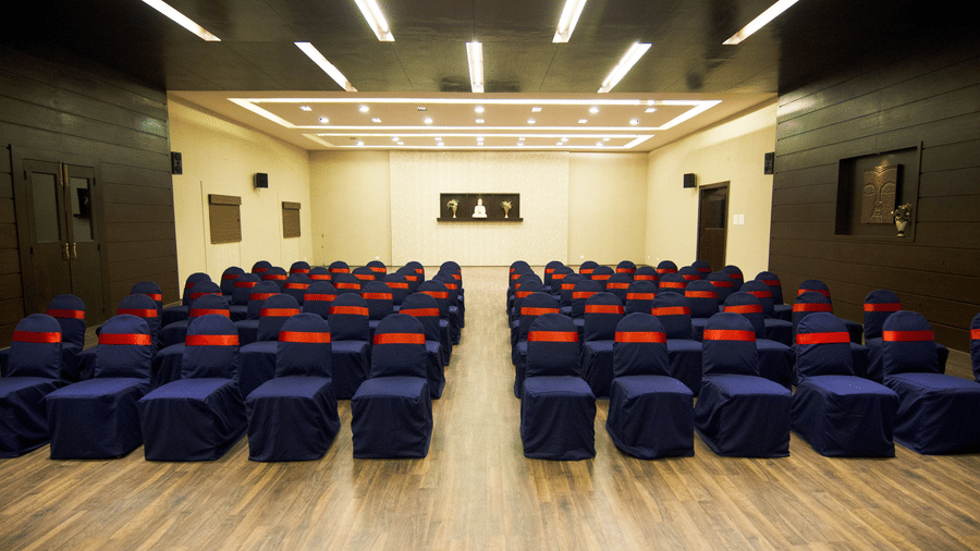 The large Lantana banquet hall at DNC Shevaroys Resort & Spa with rows of clothed chairs arranged in a theatre-style layout on a wooden floor.