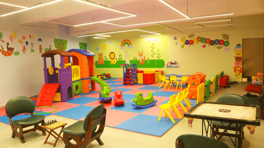 An indoor kids' play area at DNC Shevaroys Resort & Spa with colourful floor mats, toy climbers, and animal murals on the walls.
