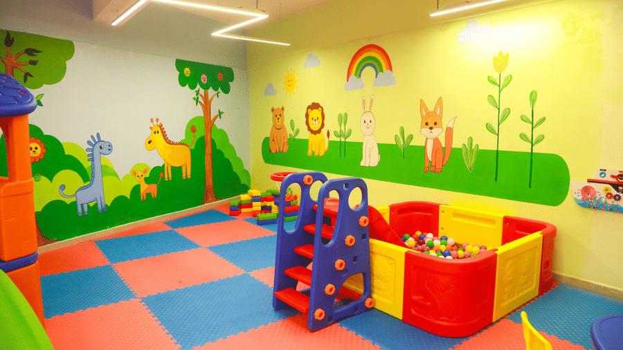 A close-up of a plastic indoor play structure with a slide and tunnel for children at DNC Shevaroys Resort & Spa.
