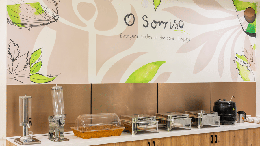 A buffet area with food warmers and a wall graphic at Elysium Studio Suites, Madhapur, shows food service equipment.