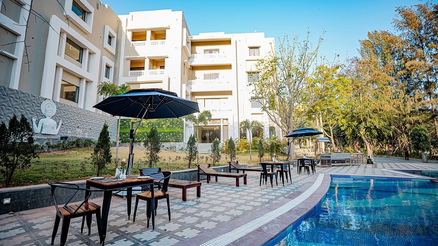 A view of the dining setting placed by the pool at Essentia Luxury Resort & Spa, Udaipur.