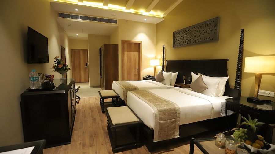 Studio Quad Room with double beds placed in front of TV at Essentia Luxury Resort & Spa, Udaipur.