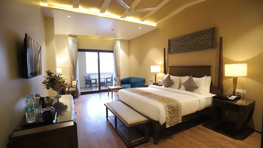 Premium room with a king size bed placed in front of a TV at Essentia Luxury Resort & Spa, Udaipur.