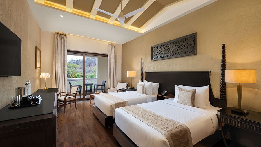 Premium room with a two single size beds placed in front of a TV at Essentia Luxury Resort & Spa, Udaipur.