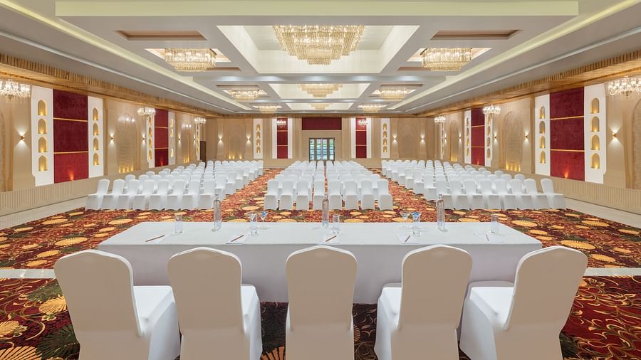 Grand Ballroom banquet with chair setting facing towards the stage with a group of chairs placed in front of a single table at A dining setting of Blue Salt and Coffee at Essentia Luxury Resort & Spa, Udaipur.. 