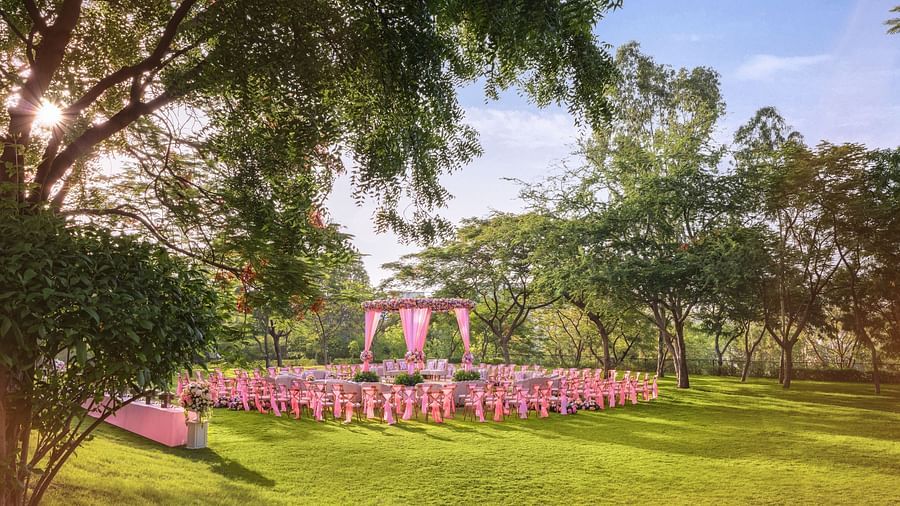An elegant setting of chairs facing towards the stage in a lawn on a sunny day at Essentia Luxury Resort & Spa, Udaipur. 