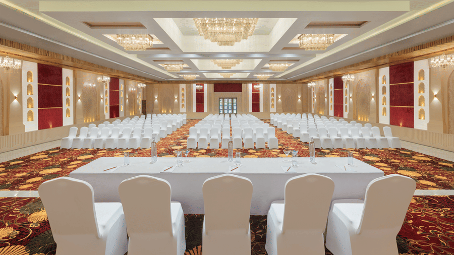 Grand Ballroom banquet with chair setting facing towards the stage with a group of chairs placed in front of a single table.