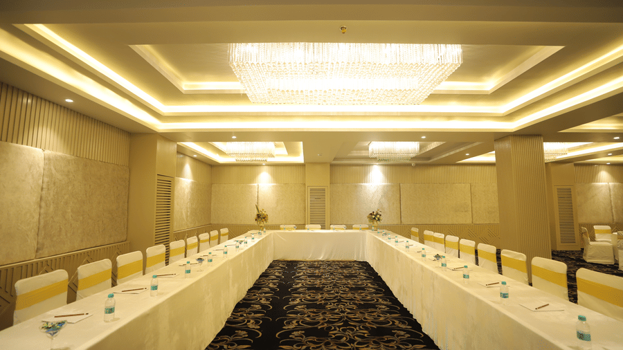 An elegant conference hall features a U-shaped table setup at Essentia Luxury Resort & Spa, Udaipur.