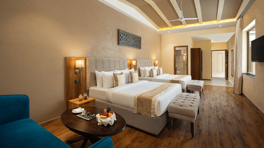 Studio Quad Room with double beds placed in front of TV at Essentia Luxury Resort & Spa, Udaipur.