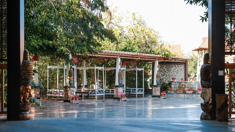 View from a dark interior looking out toward the bright courtyard and garden pathways of Estherea Resort & Spa, Jaipur.