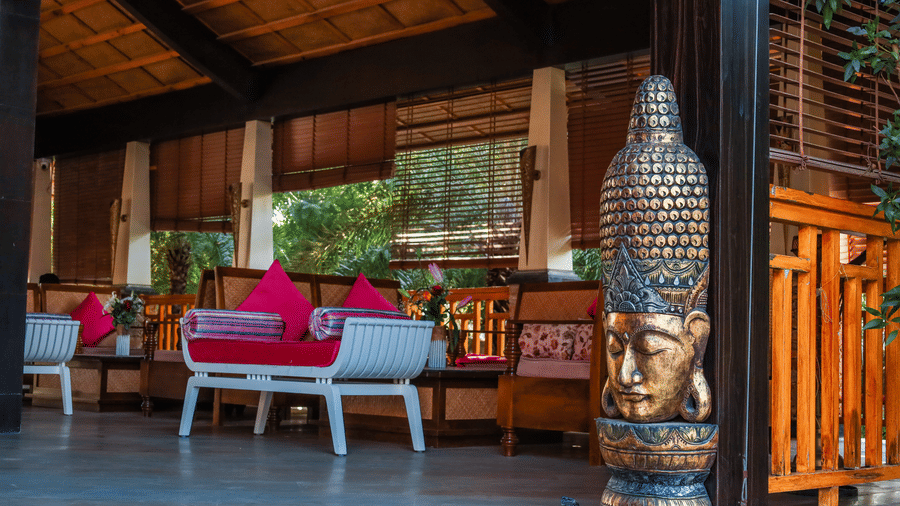 Decorative Buddha head sculpture on a pedestal situated in the corner of a lounge area at Estherea Resort & Spa, Jaipur.