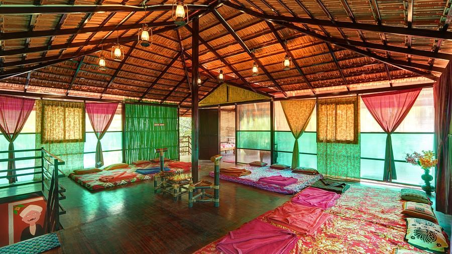 Another view of the attic in wooden cottage with comfortable beds, a high ceiling and a ladder to reach the below room - Evergreen County