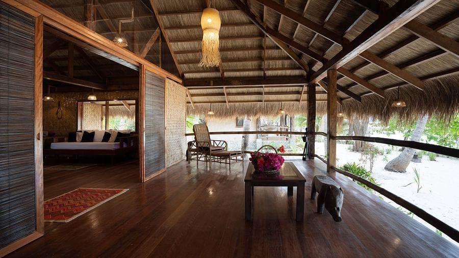 Wooden deck at Flower Island Resort with chairs and table, partially open to garden views.