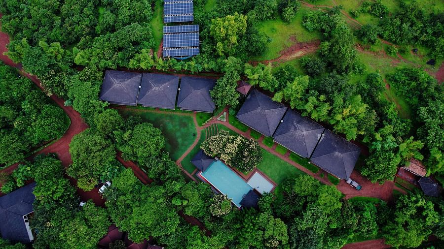 An aerial perspective of Forest Escape reveals cabins nestled in dense foliage, along with a swimming pool.